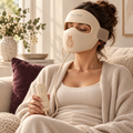 Woman relaxing on a sofa wearing the Hello Face M300 mask and holding its controller.